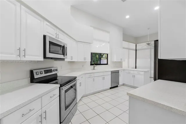 a kitchen with white cabinets and stainless steel appliances