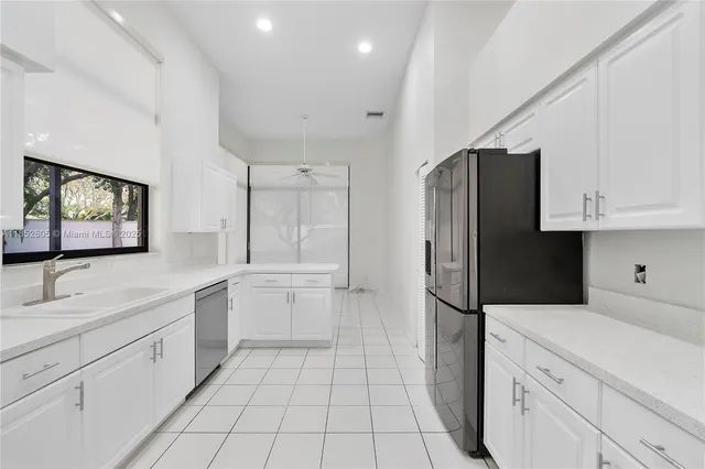 a kitchen with stainless steel appliances a refrigerator sink and microwave