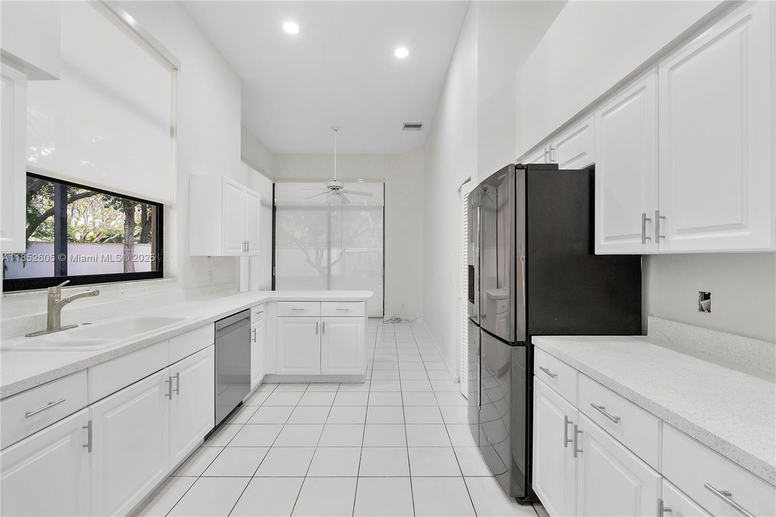 2449 Northwest 64th Street Boca Raton, FL 33496 - Photo 17 of 50 a kitchen with a refrigerator sink and cabinets