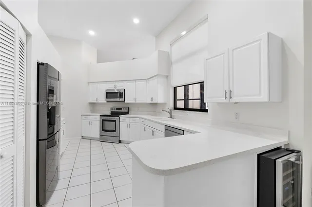 a kitchen with stainless steel appliances a refrigerator sink and microwave