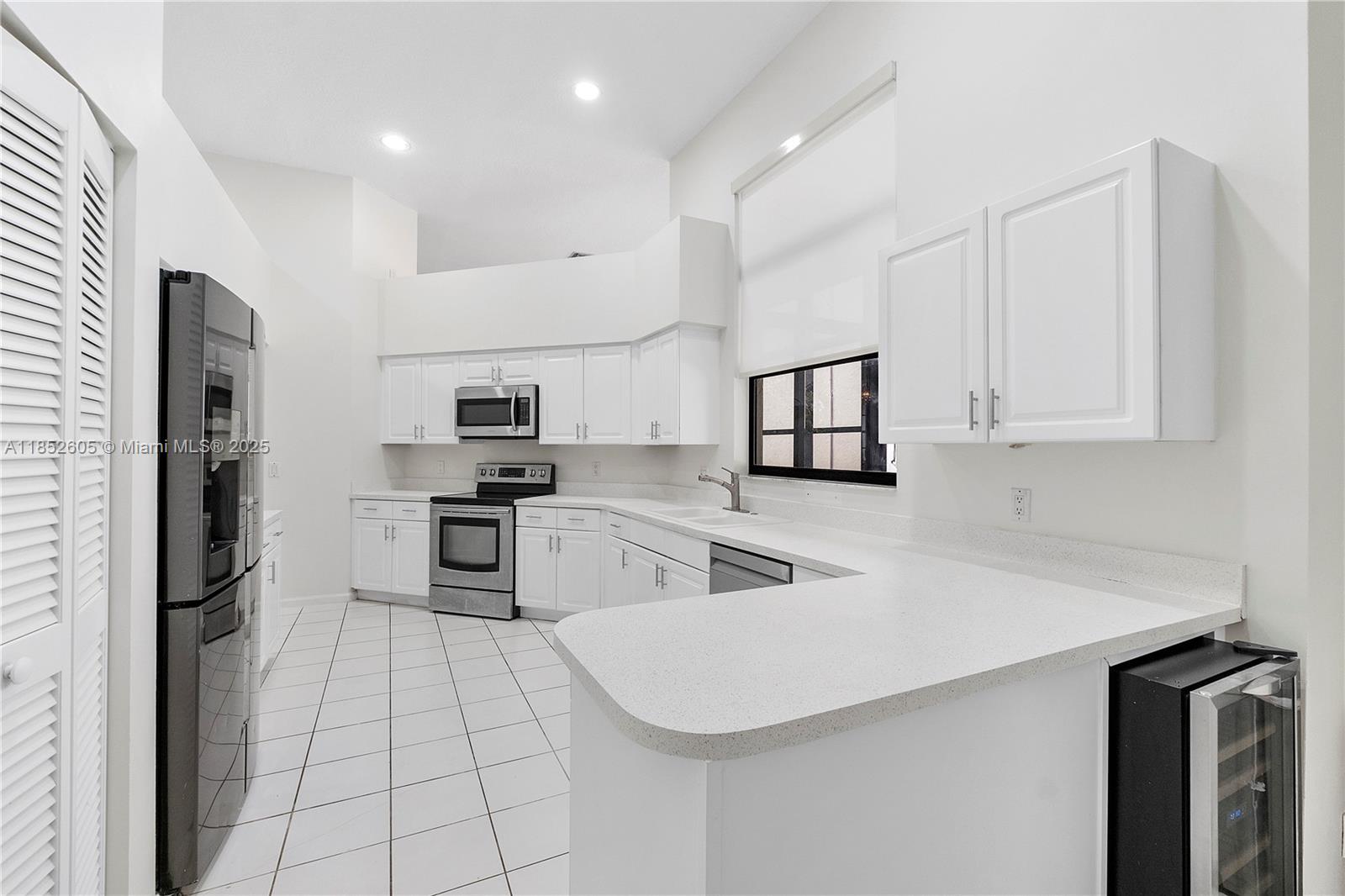 2449 Northwest 64th Street Boca Raton, FL 33496 - Photo 18 of 50 a kitchen with white cabinets and stainless steel appliances