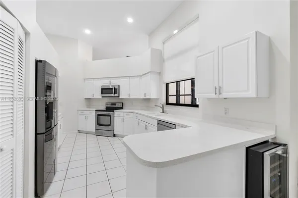 a kitchen with stainless steel appliances a refrigerator sink and microwave