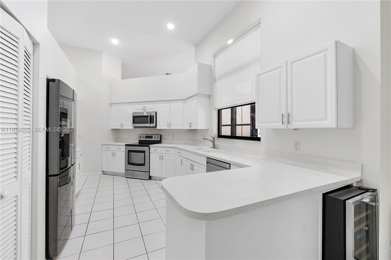 2449 Northwest 64th Street Boca Raton, FL 33496 - Photo 18 of 50 a kitchen with white cabinets and stainless steel appliances