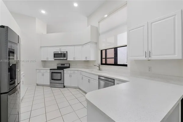 a kitchen with stainless steel appliances a refrigerator sink and microwave