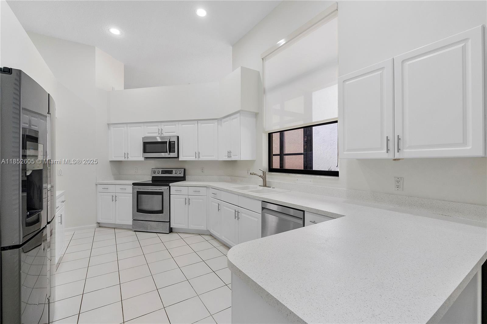 2449 Northwest 64th Street Boca Raton, FL 33496 - Photo 19 of 50 a kitchen with stainless steel appliances a refrigerator sink and microwave