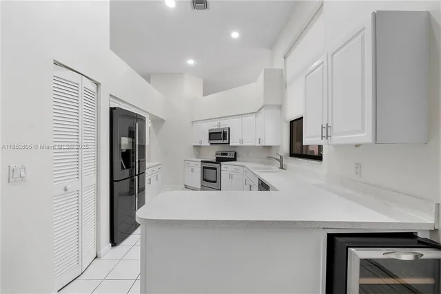 a kitchen with white cabinets and white appliances