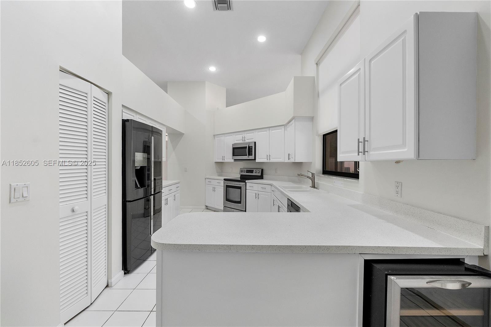 2449 Northwest 64th Street Boca Raton, FL 33496 - Photo 20 of 50 a kitchen with stainless steel appliances a refrigerator sink and microwave