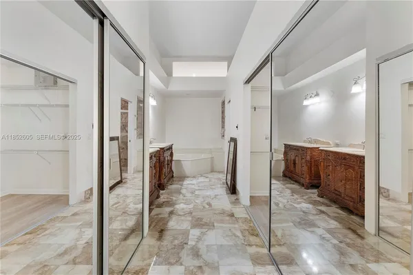 a spacious bathroom with a double vanity sink a mirror and a bathtub