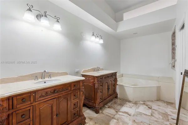 a spacious bathroom with a bathtub sink and a mirror