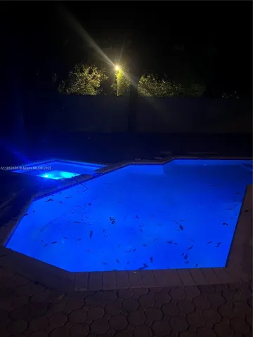 a view of a golf ground with large trees