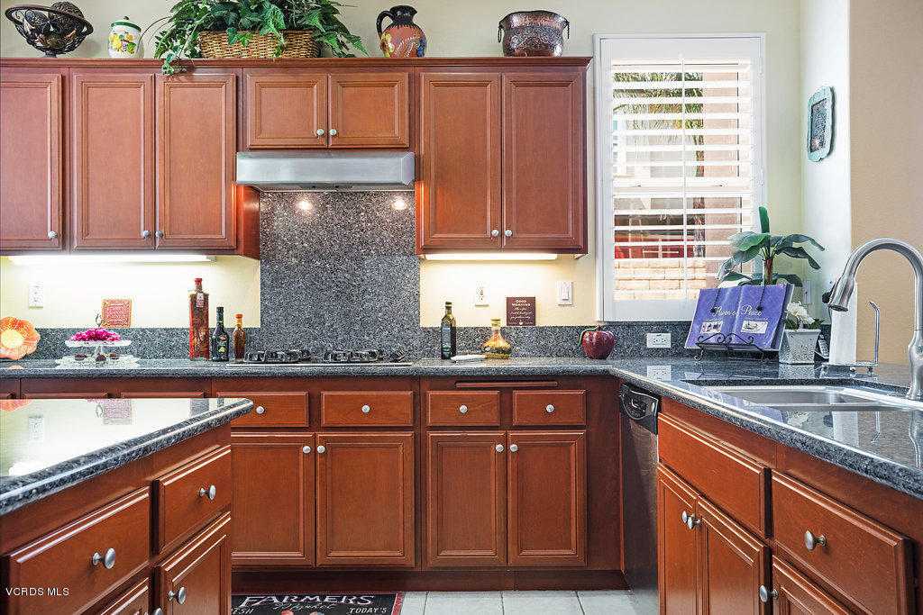 13709 Swift Run Street Moorpark, CA 93021 - Photo 12 of 34 a kitchen with granite countertop wooden cabinets a sink and dishwasher next to a window