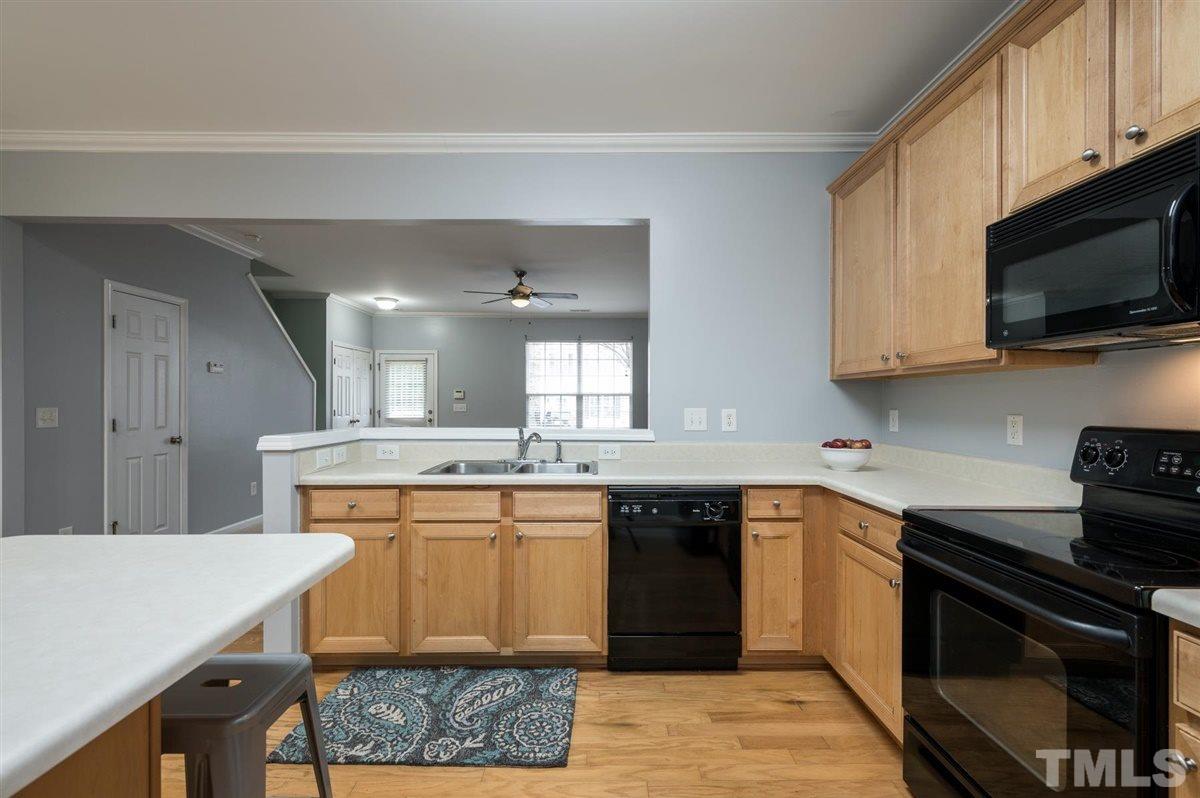 8311 Clasara Circle Raleigh, NC 27613 - Photo 14 of 27 a kitchen with stainless steel appliances granite countertop a sink stove and microwave