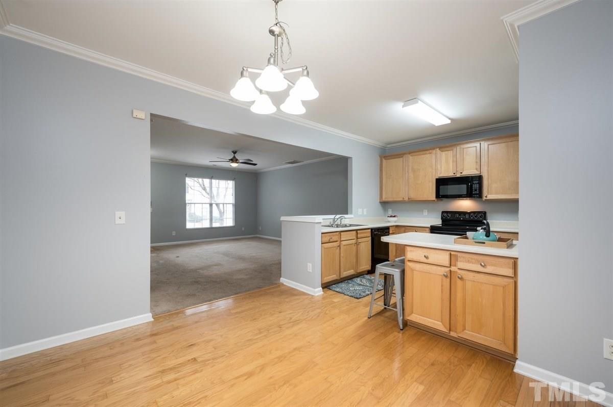 8311 Clasara Circle Raleigh, NC 27613 - Photo 10 of 27 a kitchen with stainless steel appliances granite countertop a stove top oven a sink dishwasher and a refrigerator with wooden floor