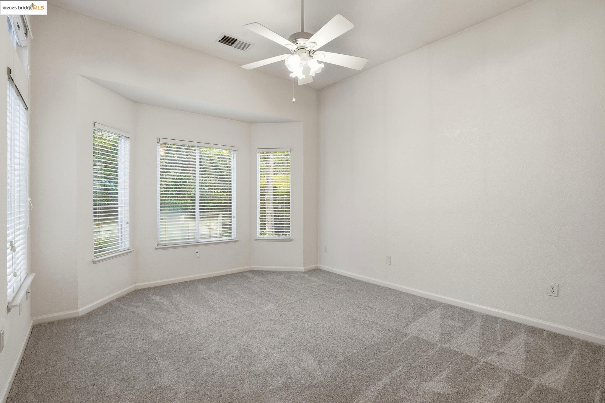 385 Ruby Terrace Brentwood, CA 94513 - Photo 12 of 37 an empty room with a window and a ceiling fan