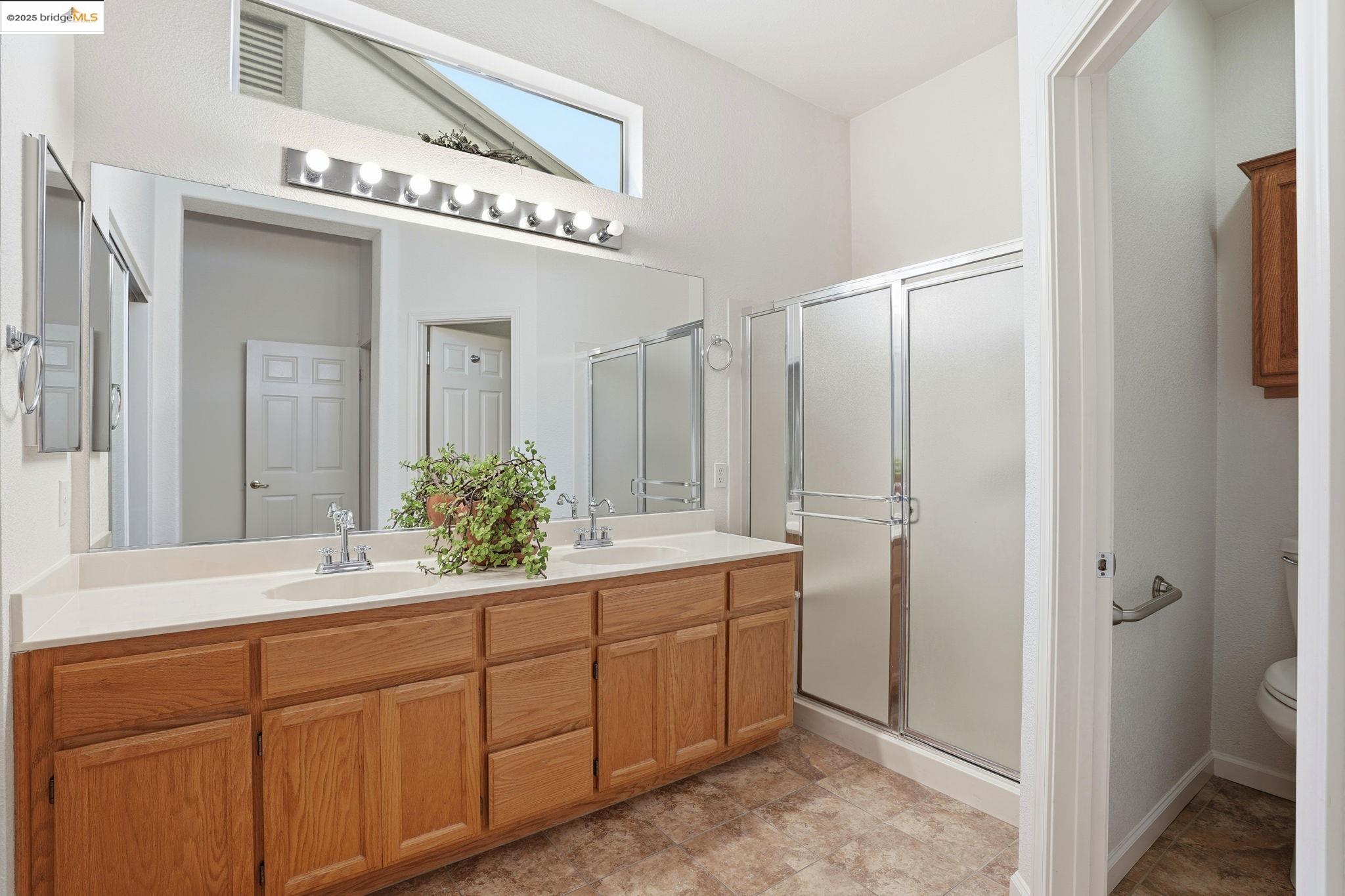 385 Ruby Terrace Brentwood, CA 94513 - Photo 14 of 37 a spacious bathroom with a double vanity sink a mirror and a shower
