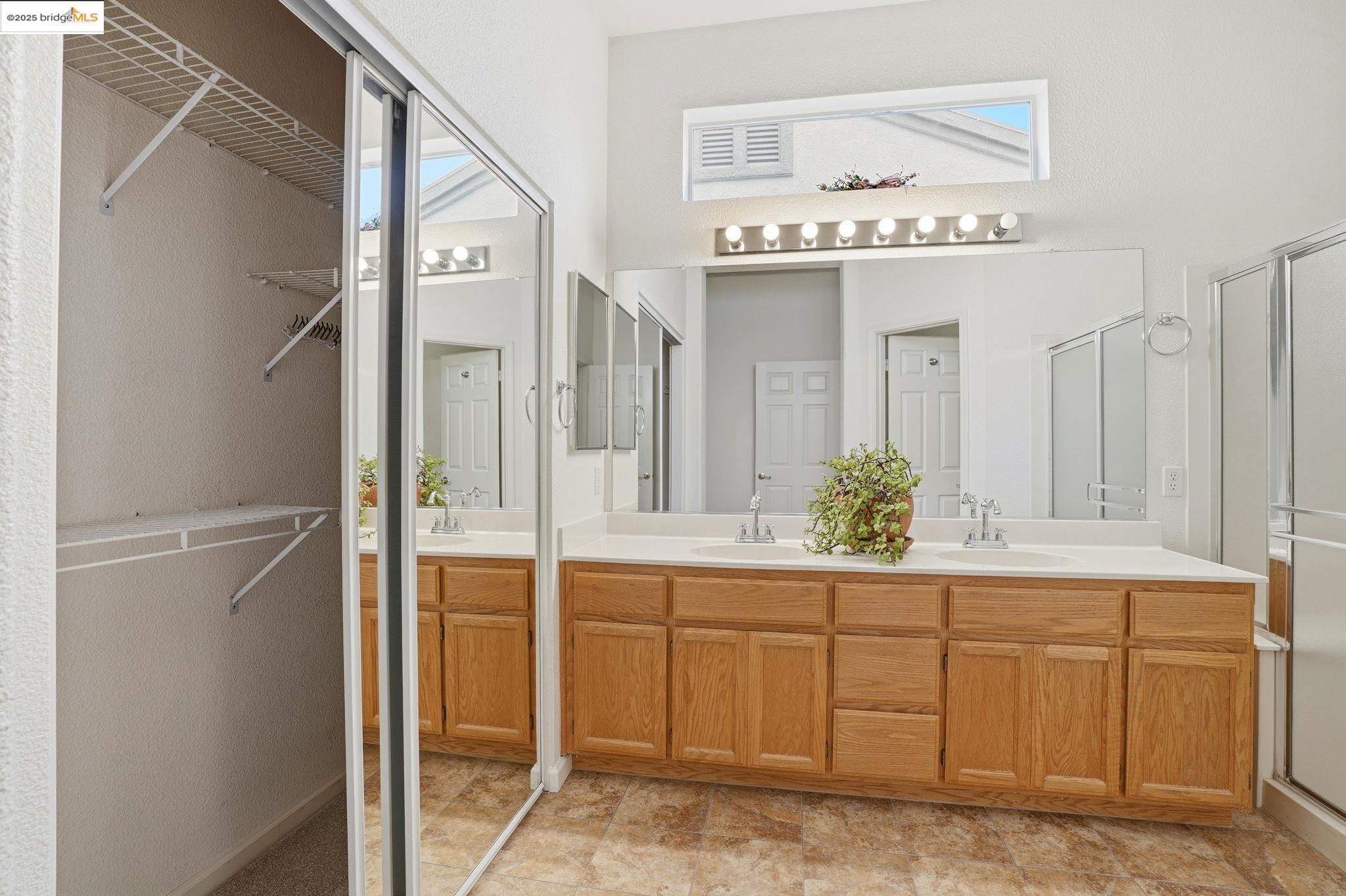 385 Ruby Terrace Brentwood, CA 94513 - Photo 15 of 37 a spacious bathroom with a sink a mirror and a shower