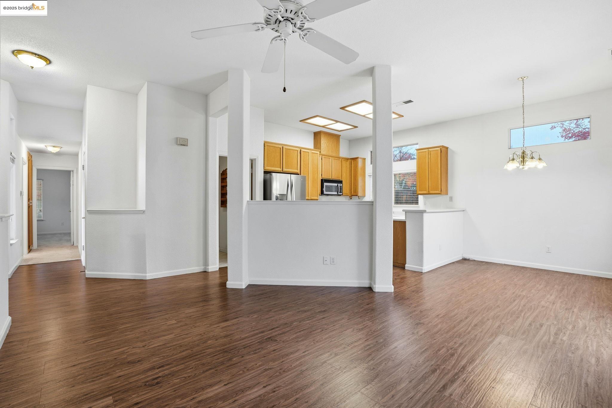 385 Ruby Terrace Brentwood, CA 94513 - Photo 8 of 37 a view of a kitchen with a refrigerator a microwave and a wooden floor