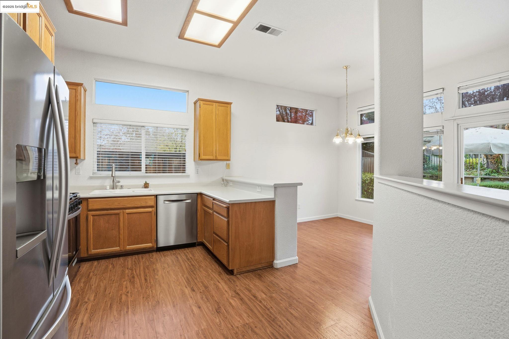 385 Ruby Terrace Brentwood, CA 94513 - Photo 9 of 37 a kitchen with stainless steel appliances granite countertop a stove a sink and a refrigerator with wooden floor