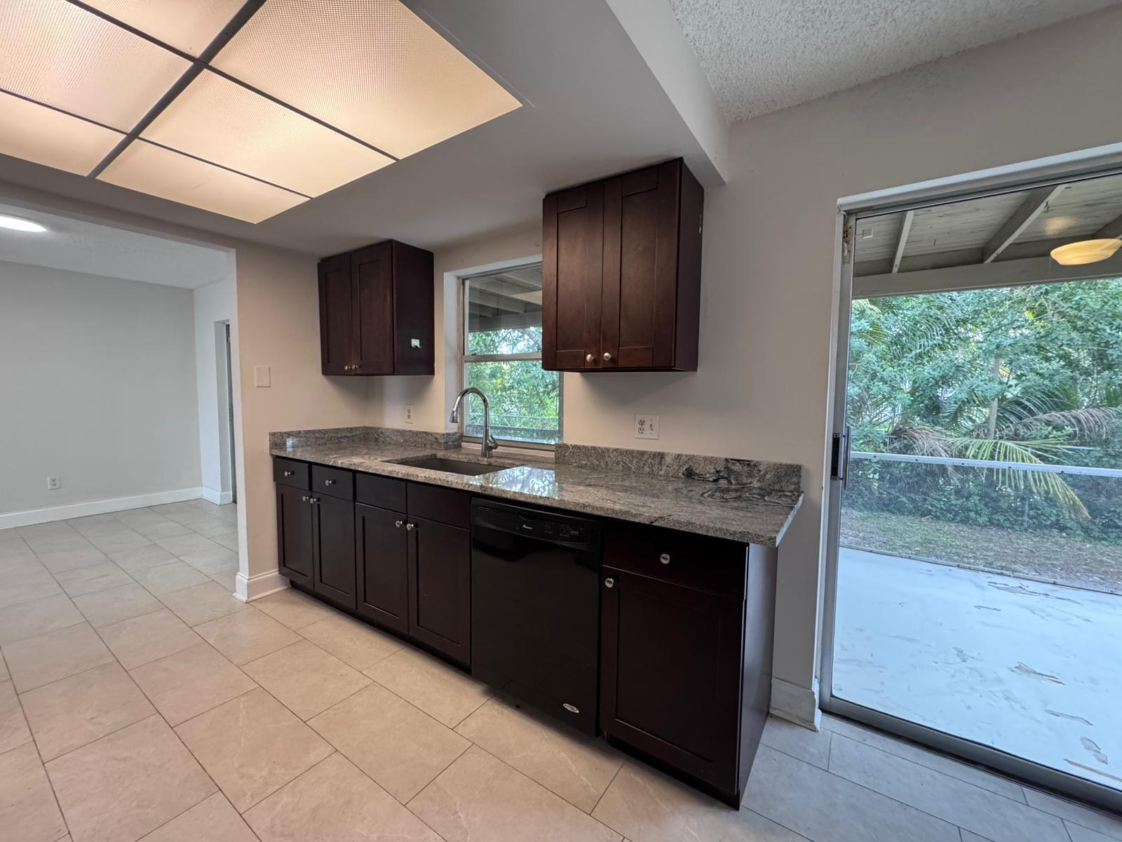 9244 Southwest 2nd Street Boca Raton, FL 33428 - Photo 3 of 11 a kitchen with a sink and a stove top oven