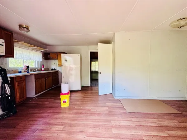 a kitchen view with wooden floor and cabinets