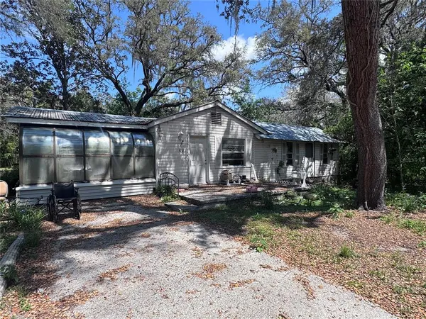 a view of a patio with chairs and a small yard