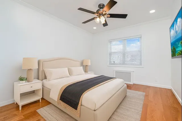 a bedroom with a large bed and a chandelier