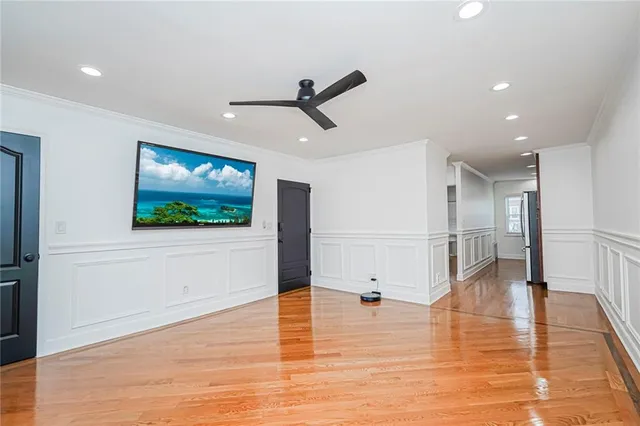 a view of a livingroom with wooden floor and a ceiling fan