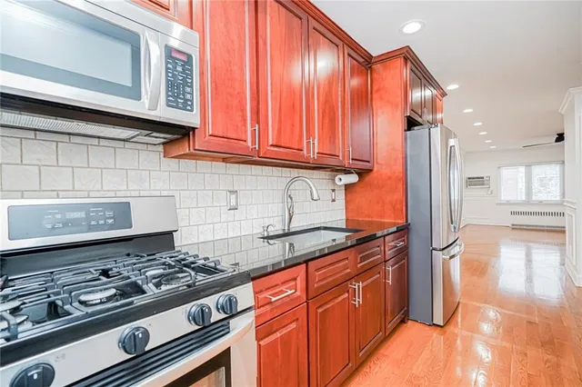 a kitchen with stainless steel appliances granite countertop a stove and a wooden cabinets
