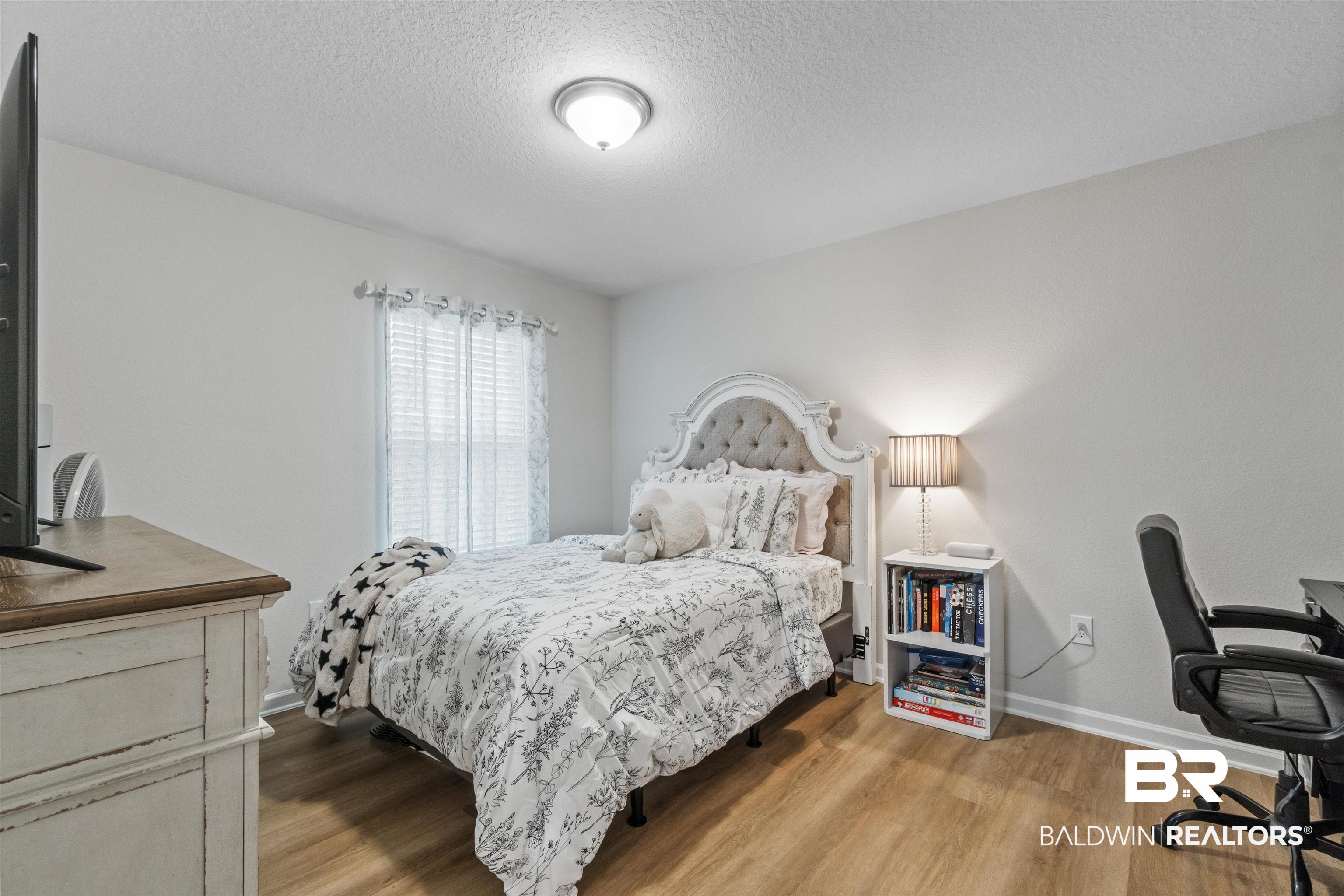 24390 Ringneck Loop Elberta, AL 36530 - Photo 25 of 39 Bedroom featuring light hardwood / wood-style flooring and a textured ceiling
