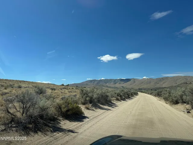 a view of a dry yard with mountains in the background