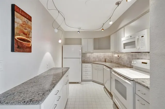 a kitchen with cabinets appliances a sink and a counter top space