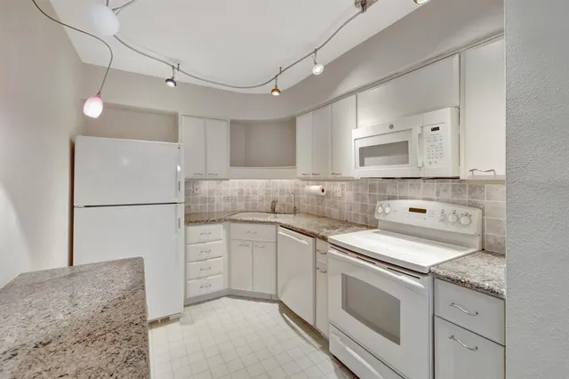 a kitchen with a stove sink and cabinets