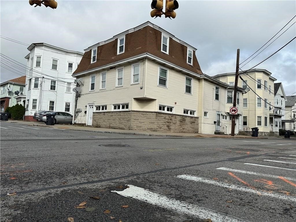 a view of a white building among the street with parked cars