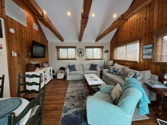 a living room with furniture a large window and a flat screen tv