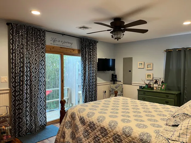 a bedroom with a bed and a flat tv screen on the dresser