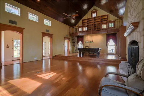 a view of a big room with wooden floor a fireplace and entryway