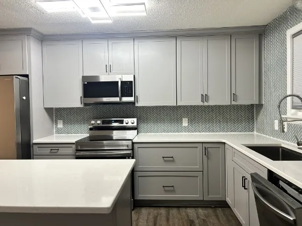 a kitchen with appliances a sink and cabinets