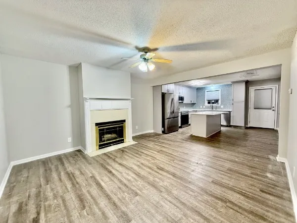 a view of empty room with wooden floor and fireplace