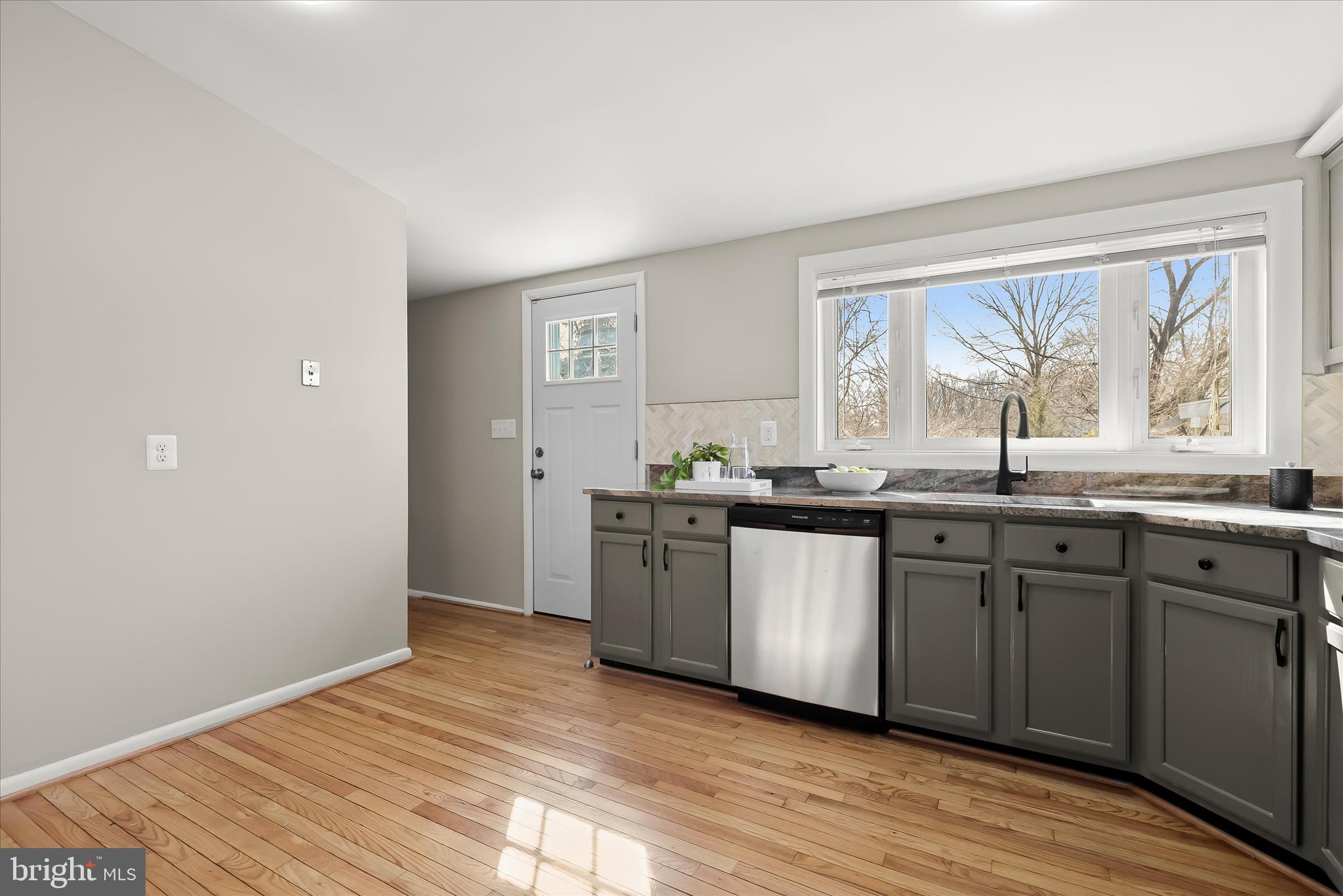 1009 Flagtree Lane Baltimore, MD 21208 - Photo 32 of 61 a kitchen with stainless steel appliances granite countertop a sink cabinets and wooden floor