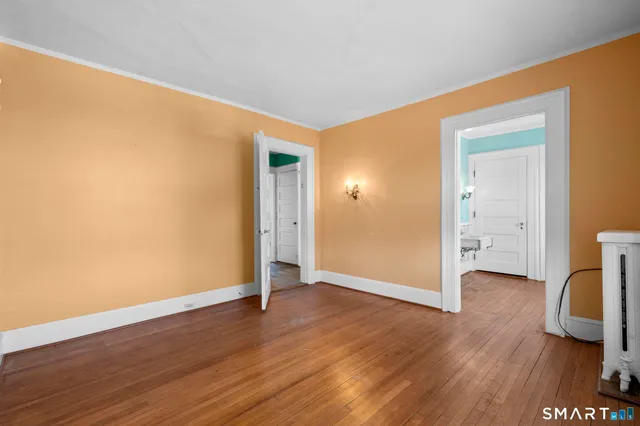 a view of an empty room with floor to ceiling window and stairs
