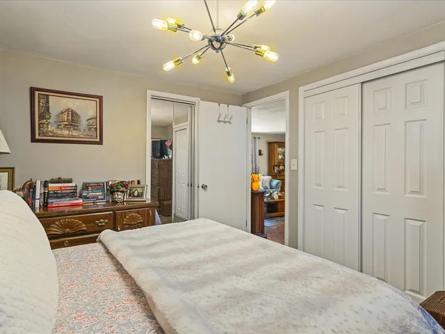 a bedroom with a large bed and a chandelier