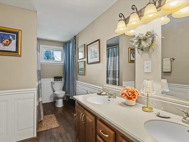 a bathroom with a granite countertop sink a toilet and a mirror