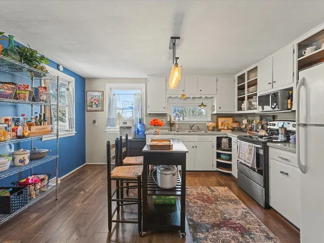 a kitchen with stainless steel appliances kitchen island granite countertop a refrigerator stove top oven and cabinets