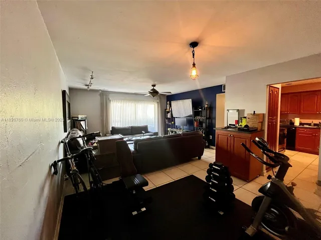 a living room with furniture kitchen view and a chandelier