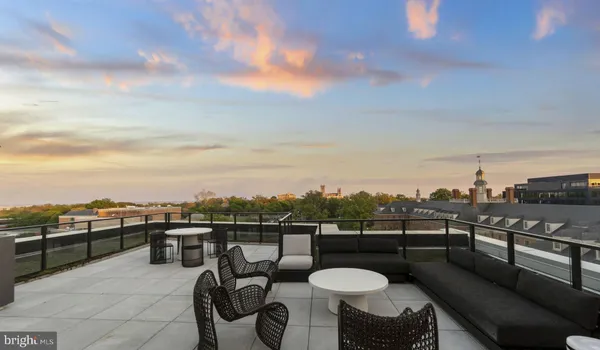 a kitchen with stainless steel appliances a stove a sink a microwave a dining table and chairs