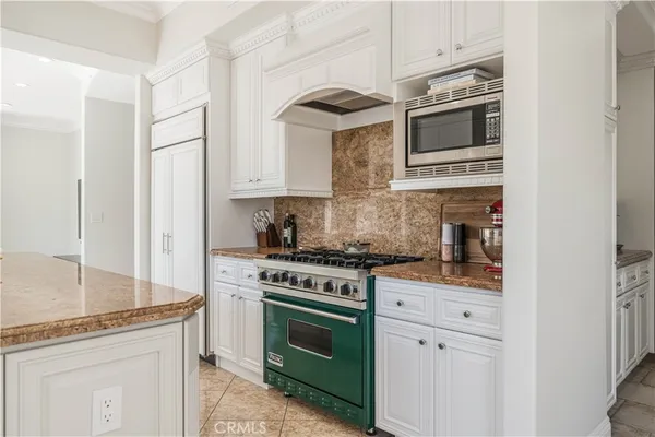 a kitchen with stainless steel appliances granite countertop white cabinets and white stove