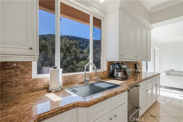 a kitchen with a sink a counter top space cabinets and a window