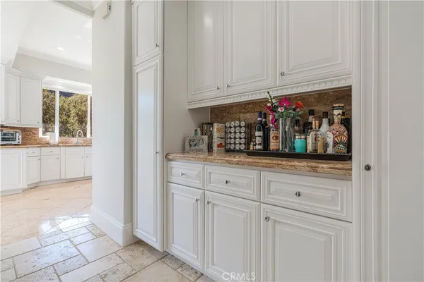 a kitchen with white cabinets and window