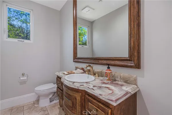 a bathroom with a granite countertop toilet sink and mirror