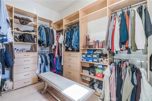 a view of walk in closet with clothes and shoes